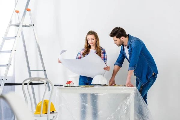 Couple looking at blueprint during home repairs — Stock Image Couple Looking Blueprint Home Repairs Royalty Free Stock Photos