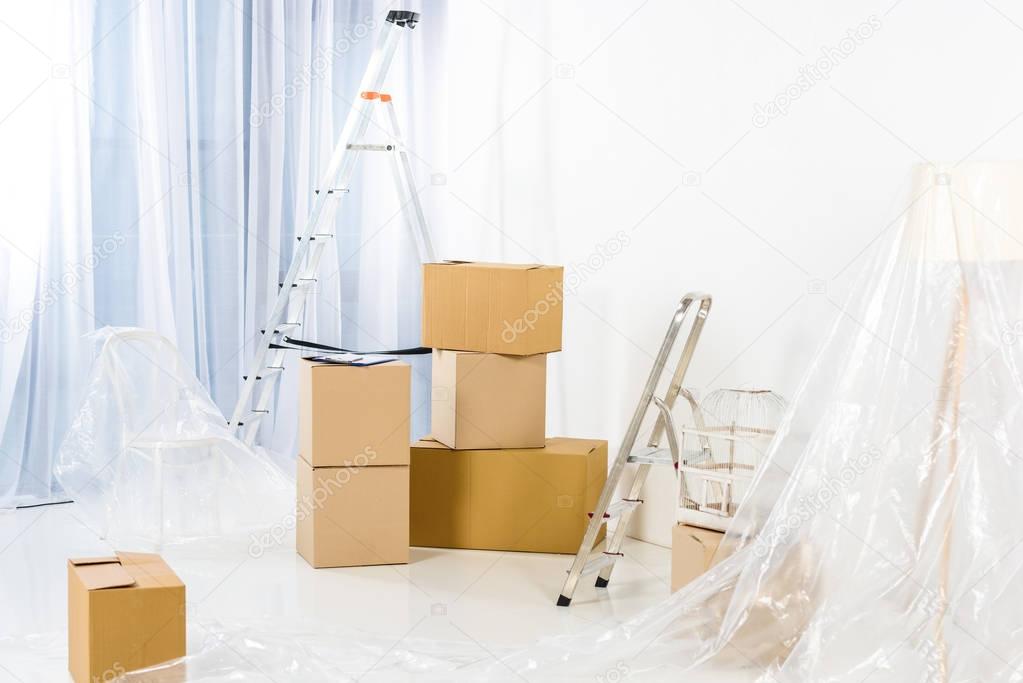 ladders and boxes in new empty apartment