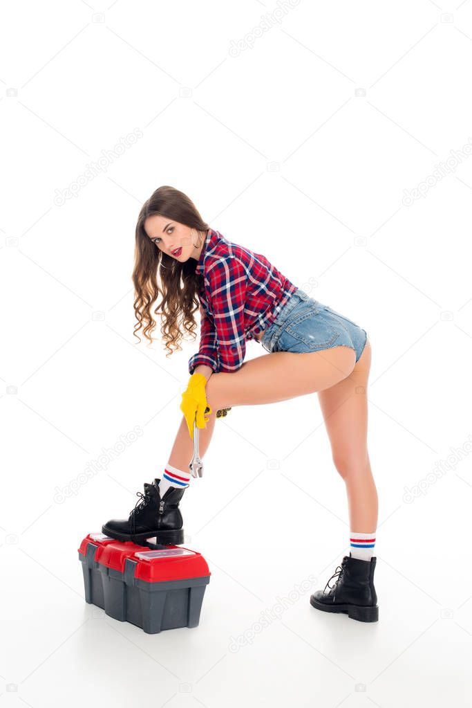 beautiful seductive girl posing with toolbox and wrench, isolated on white