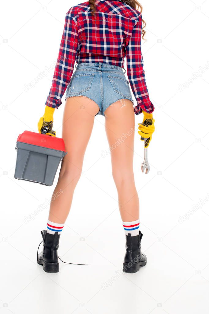 rear view of sexy girl in gloves holding toolbox and wrench, isolated on white