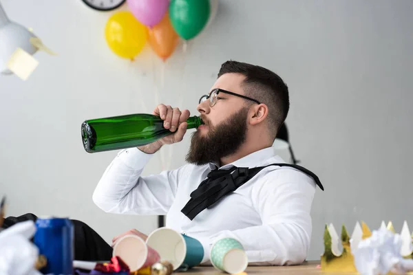 ひげを生やした実業家職場のオフィスでボトルから飲むシャンパン — ストック写真