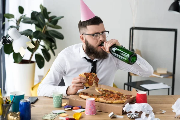 Empresário Com Cone Festa Cabeça Bebendo Champanhe Enquanto Come Pizza — Fotografia de Stock