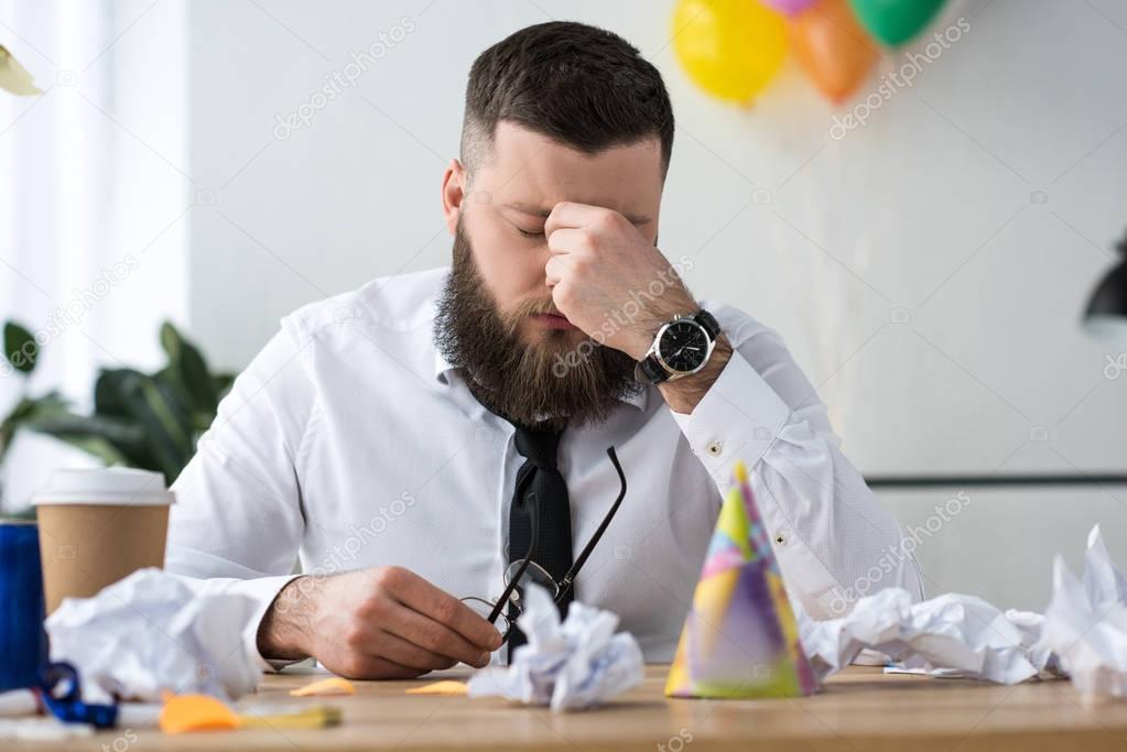 portrait of overworked businessman at workplace in office