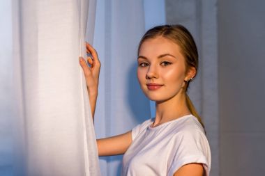 pencere yanında duran güzel genç kadın