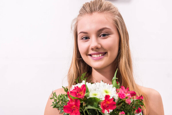 close-up portrait of young woman with beautiful bouquet looking at camera