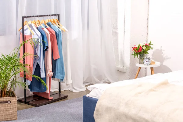 な女性の服のハンガーとモダンなベッドルームのインテリア — ストック写真