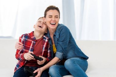 mutlu anne kucaklayan oğul birlikte video oyunları oynarken