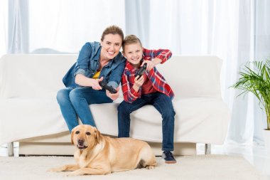 heyecanlı anne ve oğlu video oyunları oynarken onların köpek yere oturmak ve izlerken iken