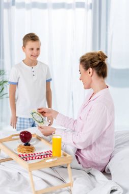 Anneler gününde anne yatakta kahvaltı veren küçük oğlu
