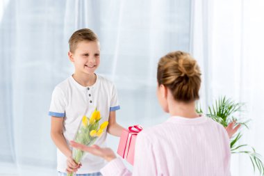 mutlu küçük oğlu hediye ve çiçek anne üzerinde anneler günü sabah sunulması