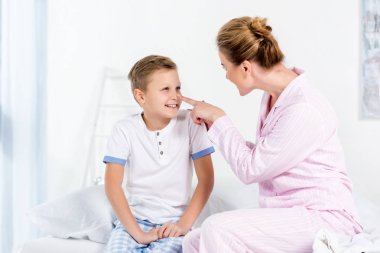 Anne ve oğul yatakta sabah oynarken