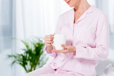 mutlu kadın pijama bardak kahve bir fincan ile kırpılmış