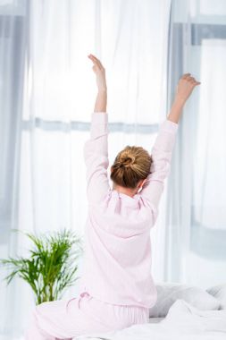 rear view of woman stretching after wake up clipart