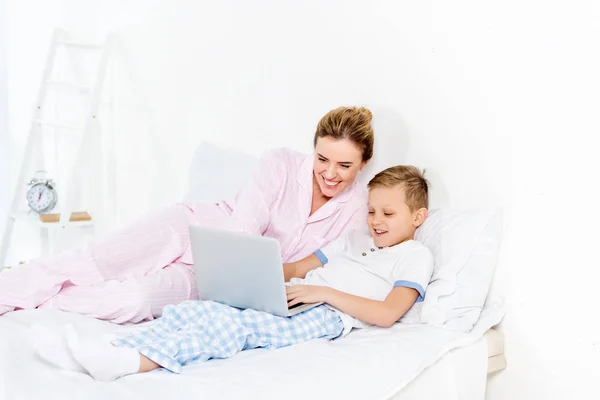 Madre Figlio Utilizzando Computer Portatile Insieme Letto — Foto stock gratuita