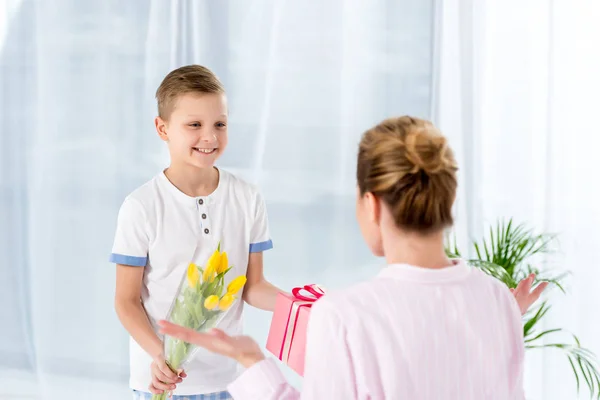 Glücklicher Kleiner Sohn Überreicht Geschenk Und Blumen Für Mutter Muttertag — Stockfoto