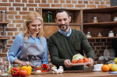 Karın kesme sebze ve koca tabak masaya koyarak