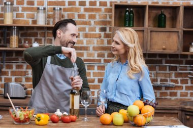 şarap şişesi tirbuşon ile açarak ve karısı arayarak koca gülümseyen