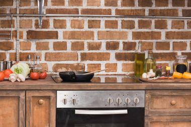 frying pan and wooden spatula on stove in kitchen clipart