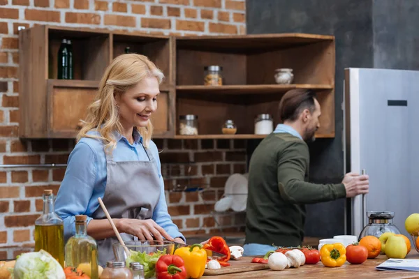 Man Ser Kylskåp Och Fru Skära Grönsaker — Stockfoto