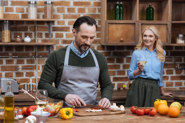 Mąż Krojenia Warzyw Żona Stojąc Przy Lampce Wina — Zdjęcie stockowe