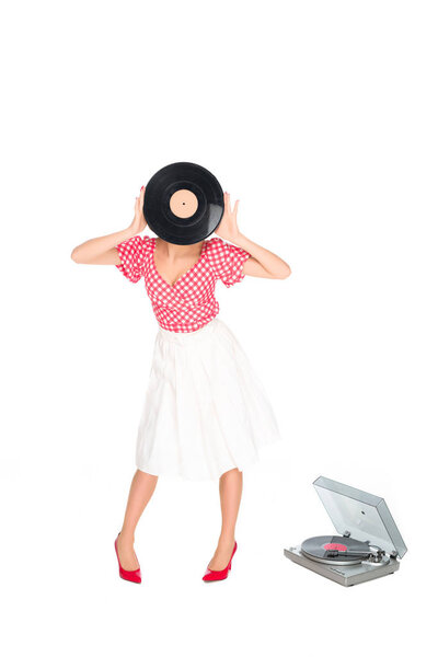 obscured view of woman in pin up style clothing covering face with vinyl record isolated on white