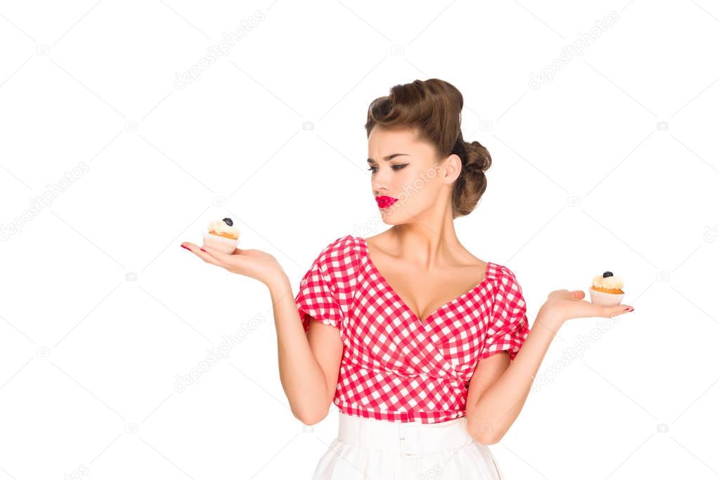 portrait of beautiful woman in pin up clothing with cupcakes isolated on white