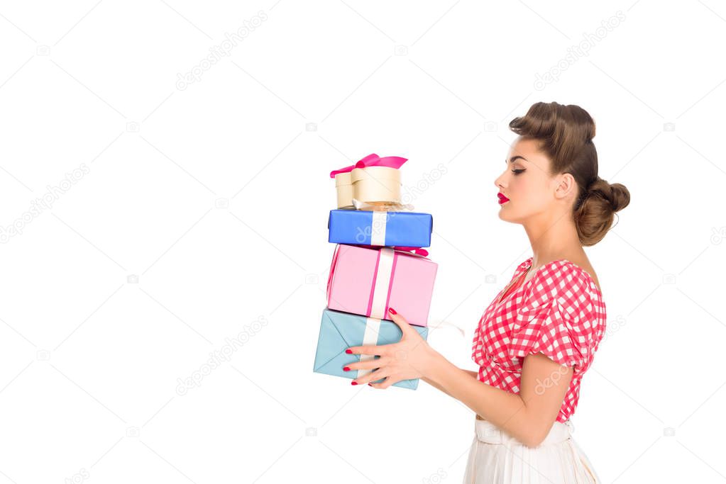 side view of beautiful woman in retro clothing holding wrapped presents isolated on white