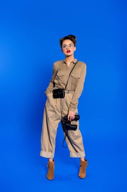 dürbün ve mavi izole fotoğraf makinesi şık genç kadınla