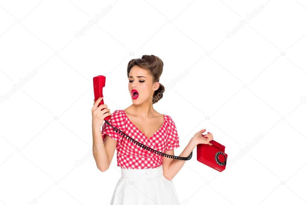 shocked pin up woman with old telephone isolated on white