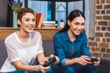 joystick ile birlikte oynayan çok ırklı kızlar gülümseyen güzel