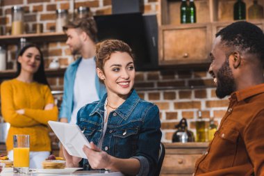 mutlu genç çok ırklı çift dijital tablet masada suyu ve krep ile kullanma 