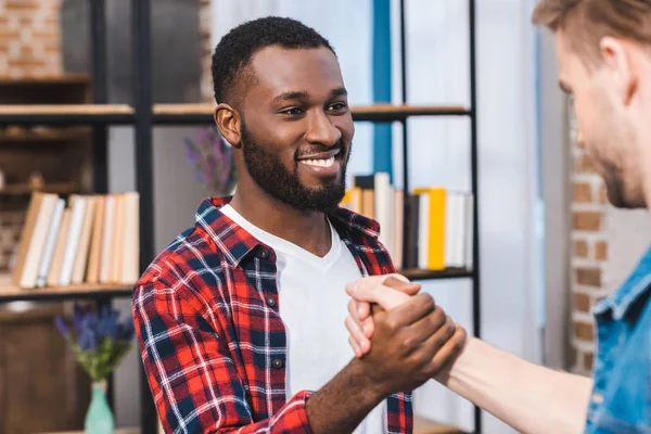 Enfoque Selectivo Los Hombres Jóvenes Multiétnicos Tomados Mano Sonriendo Entre —  Fotos de Stock