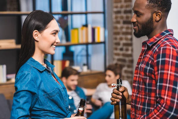 Young Multiethnic Couple Holding Bottles Beer Looking Each Other While — Stock Photo, Image