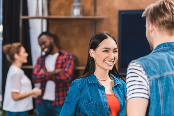 Sonriente Joven Pareja Hablando Mirándose Mientras Amigos Pie Detrás — Foto de Stock