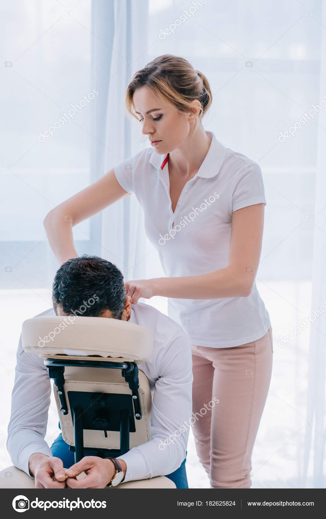 The masseur makes a relaxing massage of the trapezius muscles and back to  the client lying on the couch Stock Photo - Alamy