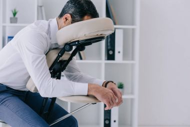 masaj koltuğu ofisinde oturan işadamı