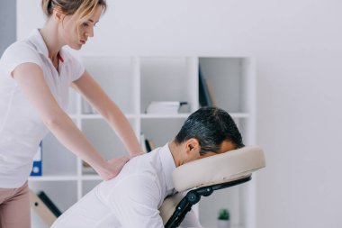 işadamı için masaj yapmaya masajcı yan görünüm oturmuş