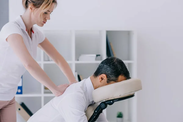 Vista Lateral Massagista Fazendo Massagem Sentada Para Homem Negócios — Fotografia de Stock
