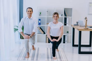 işadamı Hilal hamle onun eğitmen pratik yoga ile poz ofiste