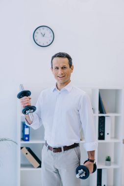 dışarı mutlu olgun işadamı workign ofisinde dumbbell ile