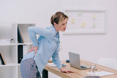 çok çalışan yetişkin iş kadını ofiste backpain ile