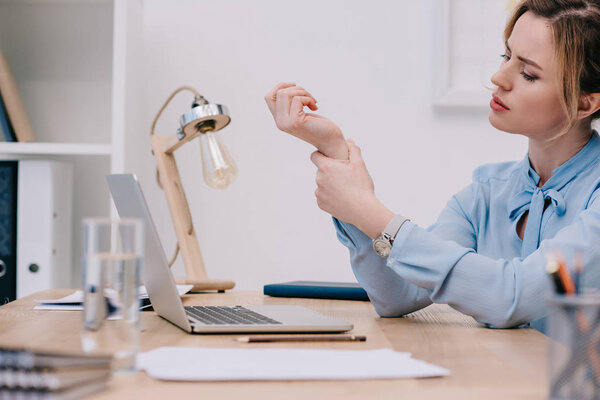 overworked businesswoman with arrhythmia measuring her heart rate at workplace
