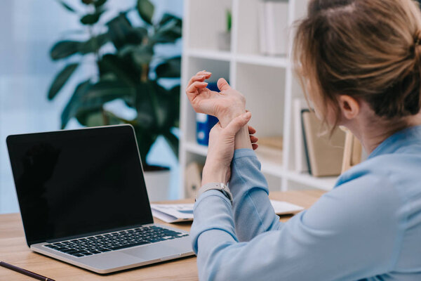 businesswoman with arrhythmia measuring her heart rate at workplace