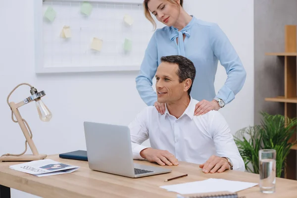 Empresário Trabalhando Com Laptop Local Trabalho Enquanto Mulher Fazendo Massagem — Fotografia de Stock