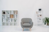 modern office interior with grey armchair and folders on shelves