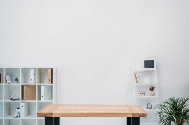Modern ofis iç boş ahşap masa ve klasörlerle raflarda