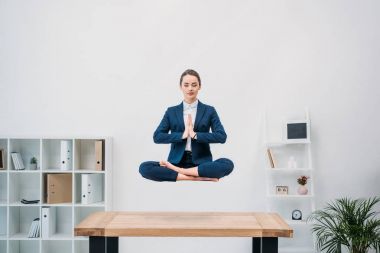 Genç işkadını kapalı gözler işyerinde levitating süre meditasyon ile 