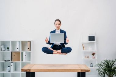 iş kadını ofiste levitating dizüstü bilgisayar kullanarak