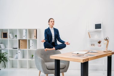 Genç işkadını Kapalı gözlerle işyerinde levitating süre meditasyon 