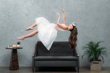 sanal gerçeklik kanepe üzerinde kulaklık levitating içinde yalınayak güzel kız
